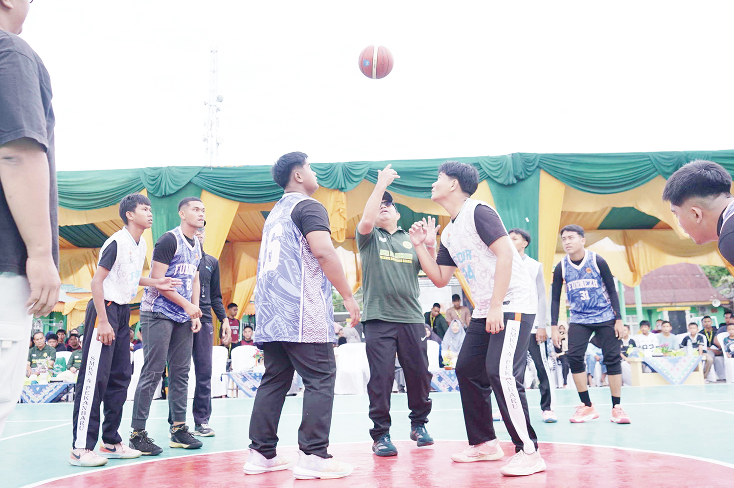 Ketua Yayasan Nur Iman Pekanbaru H Amrasul Abdullah ST MM melakukan jump Ball sebelum pertandingan pembuka DEHA Cup 2025 Basket Ball Competition di Ponpes Dar El Hikmah Pekanbaru, Ahad (16/11/2025). ft : EVAN GUNANZAR/RIAU POS