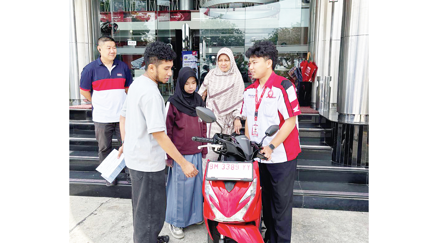 Pemenang undian hadiah utama Honda DBL with Kopi Good Day 2025 Riau Keiysa Sazami disaksikan Promotion & Advertising Selection Head PT Capella Dinamik Nusantara Hariyanto Budhiman (kiri belakang) saat penyerahan satu unit sepeda motor Honda Beat di Ca
