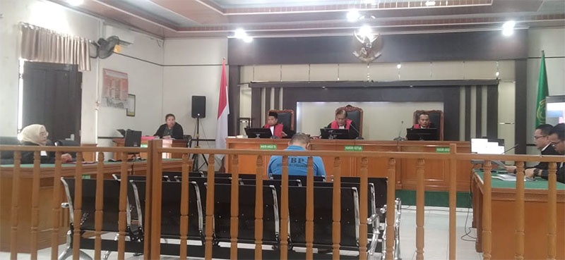 Hendra Ong (kaos biru), terdakwa kasus peredaran 1.000 pil ekstasi tertunduk hadapi dakwan JPU di PN Pekanbaru, Selasa (18/11/2025).