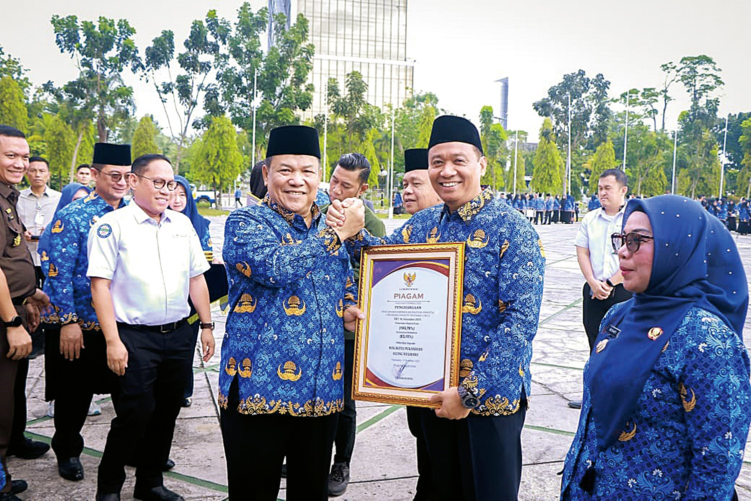 Wawako Pekanbaru Markarius Anwar menerima penghargaan dari Pemprov Riau yang diserahkan Plt Gubri SF Hariyanto atas capaian UHC di Pekanbaru, Senin (17/11/2025).