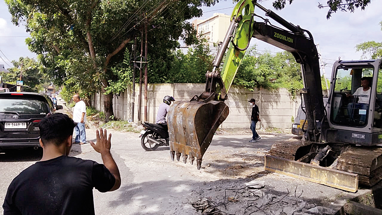 Satu unit alat berat membongkar drainase di Jalan Letkol Hasan Basri, Kecamatan Sail, Kota Pekanbaru, Senin (17/11/2025) pagi. Drainase dibongkar oleh kontraktor yang mengaku belum mendapatkan pembayaran hasil kerja proyek.