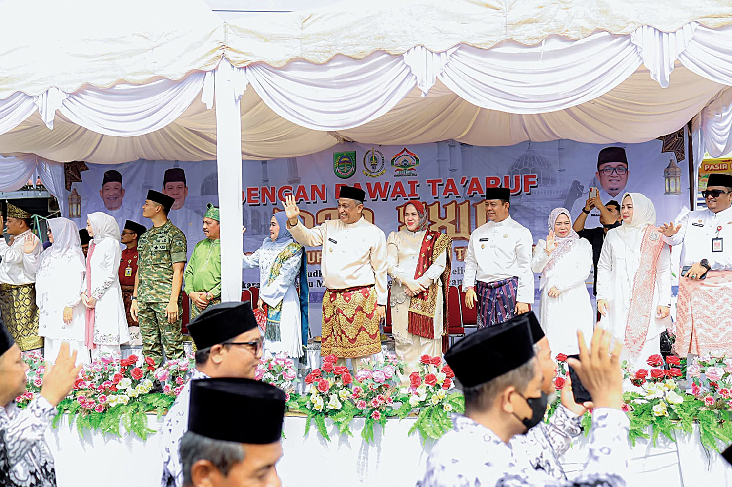 Bupati Rohul Anton ST MM bersama Wabup H Syafaruddin Poti beserta istri dan forkopimda melambaikan tangan kepada peserta pawai taaruf MTQ saat melintasi panggung utama di ruas Jalan Tuanku Tambusai, Pasirpengaraian, Senin (17/11/2025).