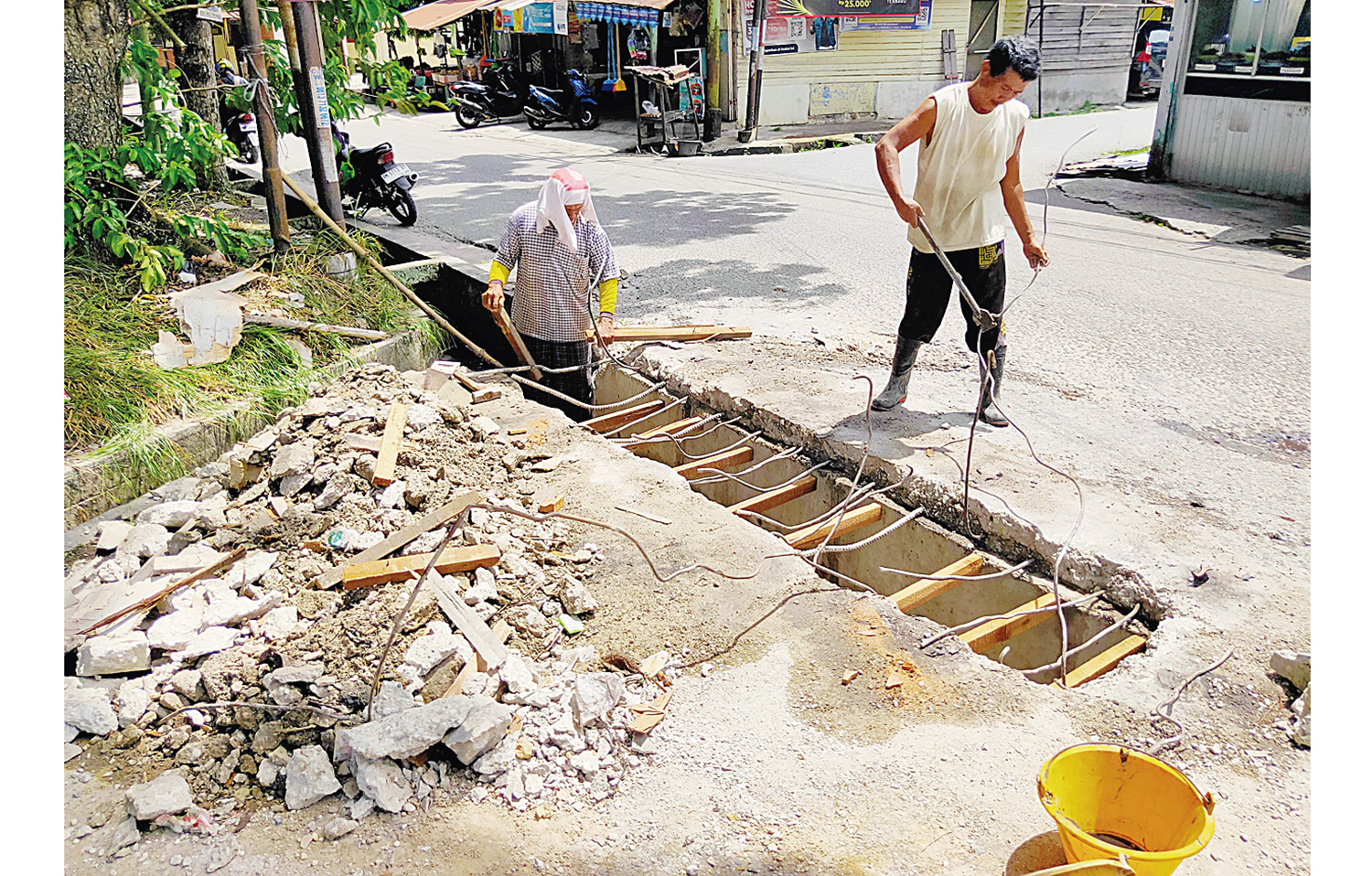 Perbaiki : Pekerja melakukan perbaikan gorong-gorong Jalan Letkol Hasan Basri Kec Sail Pekanbaru, Selasa (18/11/2025). Sebelumnya jalan ini dibongkar oleh kontraktor karena belum adanya pembayaran pengerjaan proyek ini. ft : EVAN GUNANZAR/RIAU POS