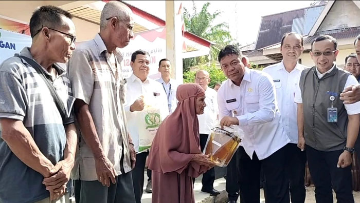 Wabup Rohul H Syafaruddin Poti didampingi Pemimpin Perum Bulog Cabang Kampar Dani Permana salurkan bantuan pangan kepada perwakilan PBP di Desa PBTJ Kecamatan Bangun Purba, Rabu (19/11/2025).