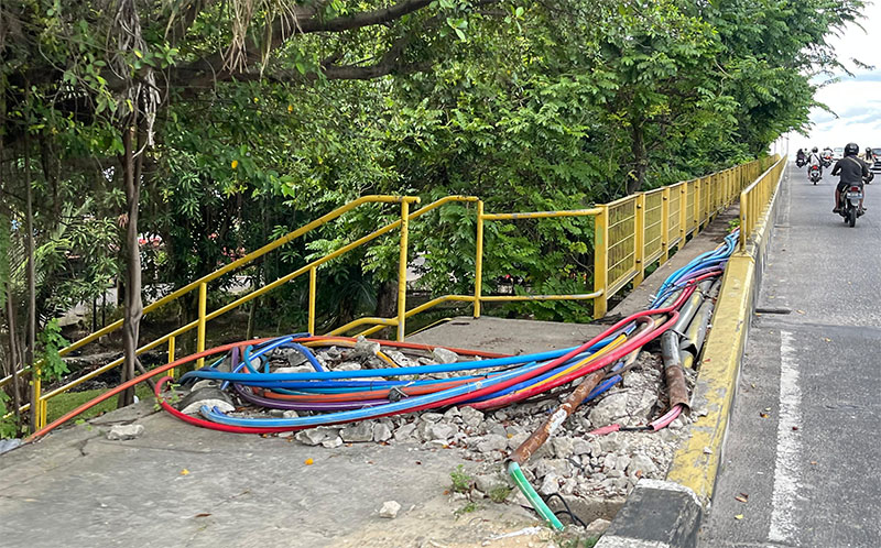 Kabel yang melintas di jalur pejalan kaki ke Jembatan Siak I