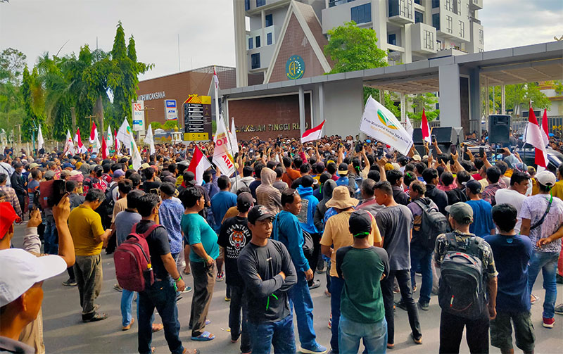 Massa melakukan aksi unjuk rasa di depan Gedung Kejaksaan Tinggi Riau, Kamis (20/11/2025).