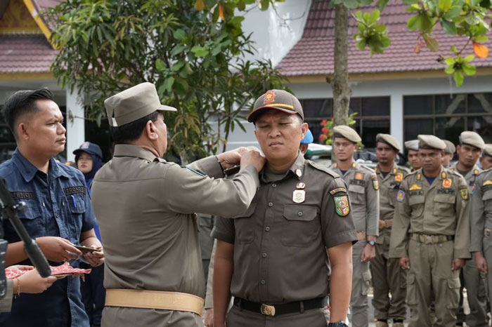 Bupati Kuansing Dr H Suhardiman Amby MM pasang pita pada personel Satpol PP-PKP Kuansing yang harus siap siaga tangani kebakaran di Kuansing dalam apel pasukan kesiapsiagaan, Jumat (21/11/2025).