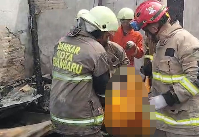 Petugas evakuasi jasad korban Kebakaran terjadi di Jalan Melur, Kelurahan Sidomulyo Barat, Panam, Kecamatan Tuah Madani Pekanbaru, pada Jumat (21/11/2025).