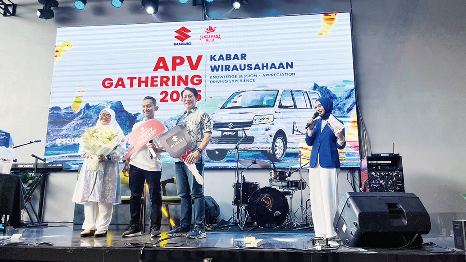 Head of Fleet Sales Group PT Suzuki Indomobil Sales Neneng Siti Nurhayati bersama Regional Manager PT Buana Indomobil Trada Santoni menyerahkan kunci secara simbolis kepada konsumen yang telah melakukan delivery unit APV dalam acara APV Gathering 2025 di