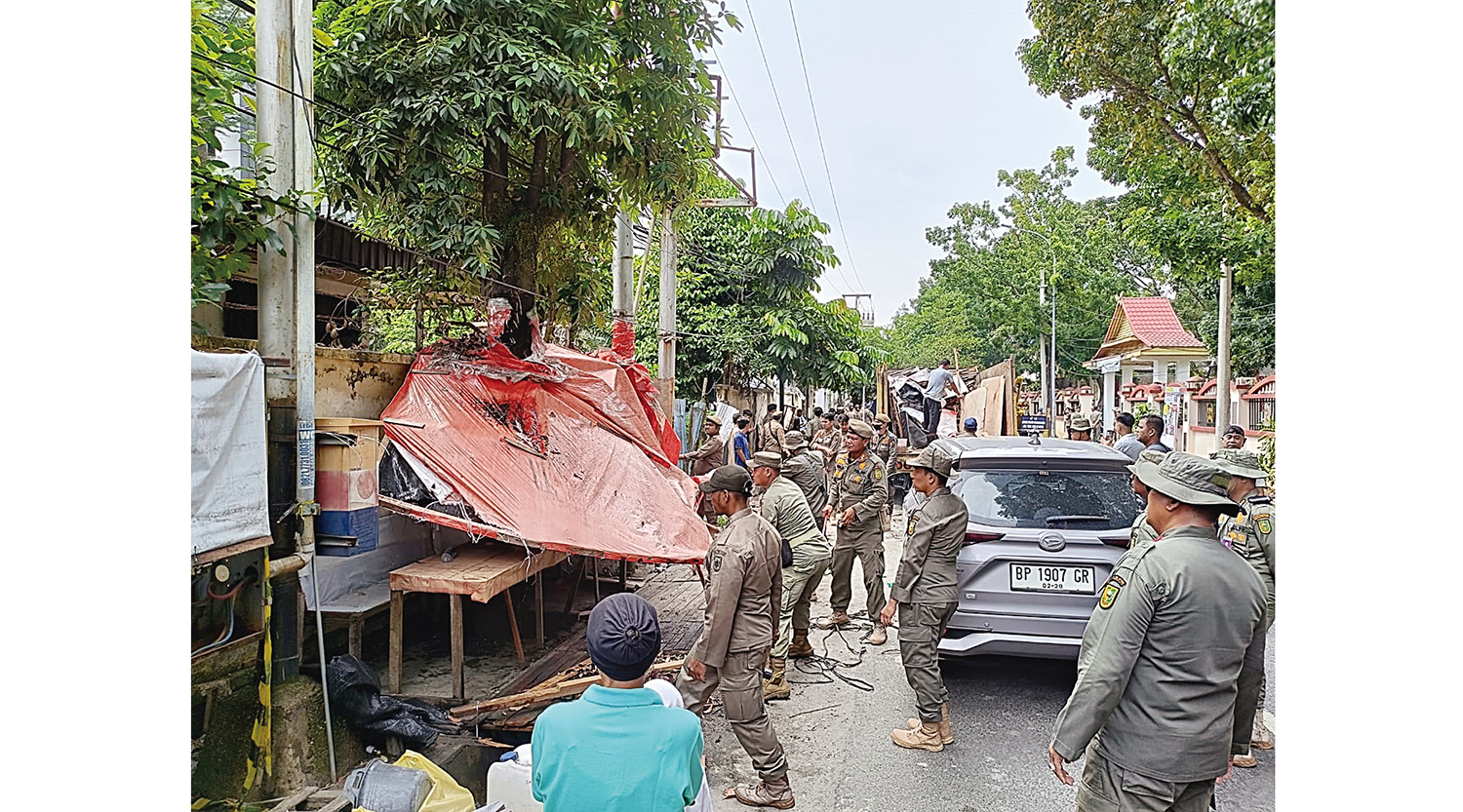 Personel Satpol PP Pekanbaru membongkar bangunan liar yang dijadikan lapak PKL di Jalan Mustika, tepatnya di samping RSUD Arifin Achmad Pekanbaru, Senin (24/11/2025).