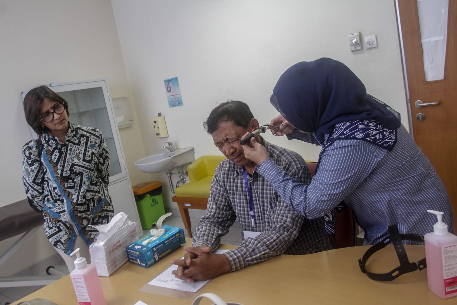 Salah satu nasabah Bank Mandiri Taspen saat mendapatkan pelayanan pemeriksaan kesehatan telinga sebelum pemasangan alat bantu dengar di Aula RSUD Arifian Achmad Pekanbaru, Sabtu (22/11/2025).