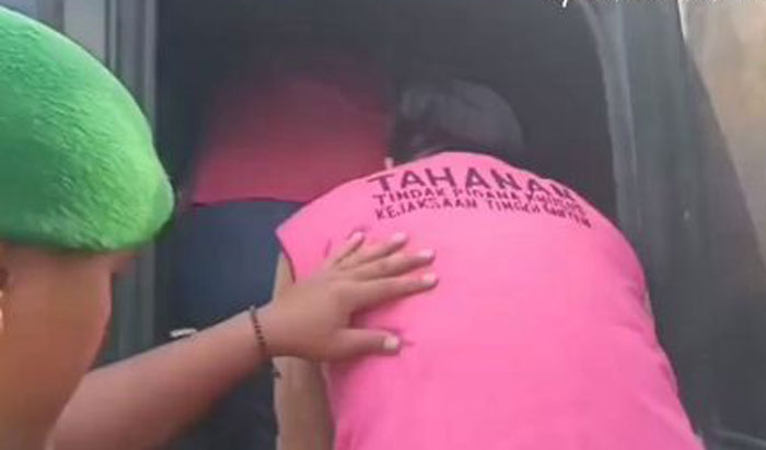 Dua tersangka kasus dugaan korupsi pembelian minyak goreng CP10 senilai Rp 20,4 miliar saat dibawa dengan mobil tahanan.