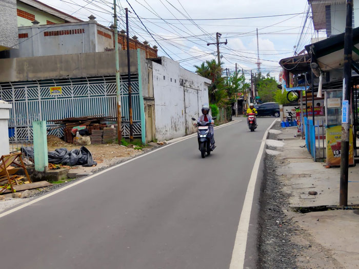 Pengendara melintas di jalan Tamtama Kec Payung Sekaki Pekanbaru yang sudah di aspal, Rabu (26/11/2025).