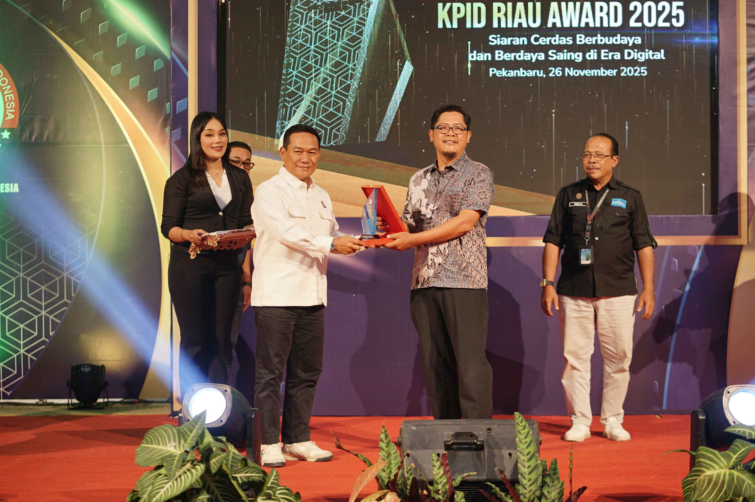 CEO  Riau Pos Group Ahmad Dardiri (dua kanan) menerima penghargaan dari Koordinator Bidang Kelembagaan KPID Riau M. Asrar Rais saat acara KPID Award 2025 di Graha Pena Riau, Rabu (26/11/2025) malam.