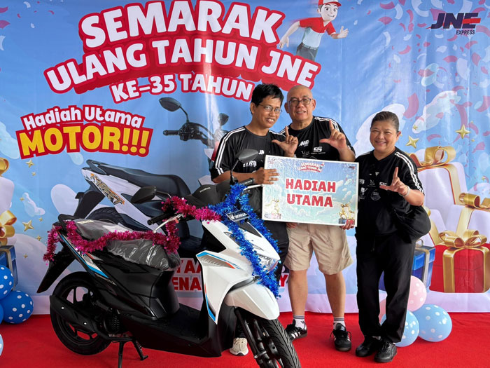 Kepala Cabang JNE Pekanbaru, Hui Mandra (tengah) menyerahkan hadiah utama berupa 1 unit sepeda motor yang dimenangkan oleh peserta bernama Muhammad Daud dalam perayaan HUT JNE belum lama ini.