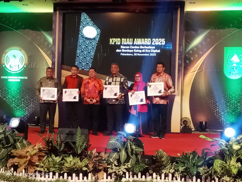 Asisten II Setda Kuansing, Drs Napisman mewakili Bupati Kuansing H Suhardiman Amby, menerima penghargaan dalam ajang KPID Award 2025 di Gedung Graha Pena Pekanbaru, Rabu (26/11/2025).