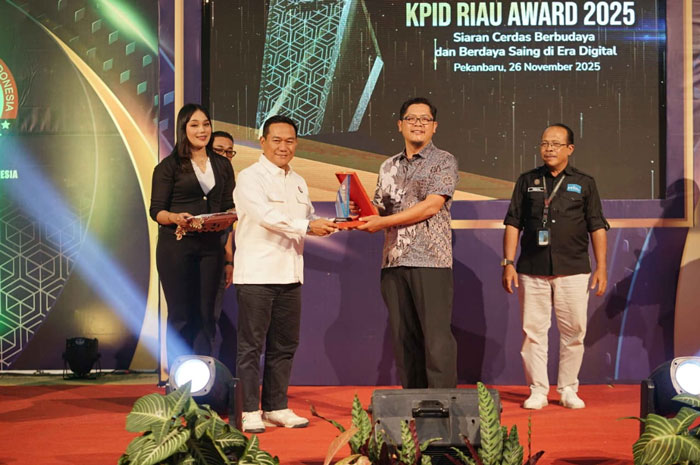 CEO Riau Pos Group Ahmad Dardiri (dua kanan) menerima penghargaan dari Koordinator Bidang Kelembagaan KPID Riau M Asrar Rais saat acara KPID Award 2025 di Graha Pena Riau, Rabu (26/11/2025) malam.