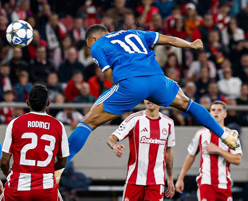 Kylian Mbappe mencetak gol dengan tandukan saat membawa Real Madrid mengalahkan Olympiacos Yunani 4-3 di Liga Champions. Mbappe memborong seluruh gol Madrid.
