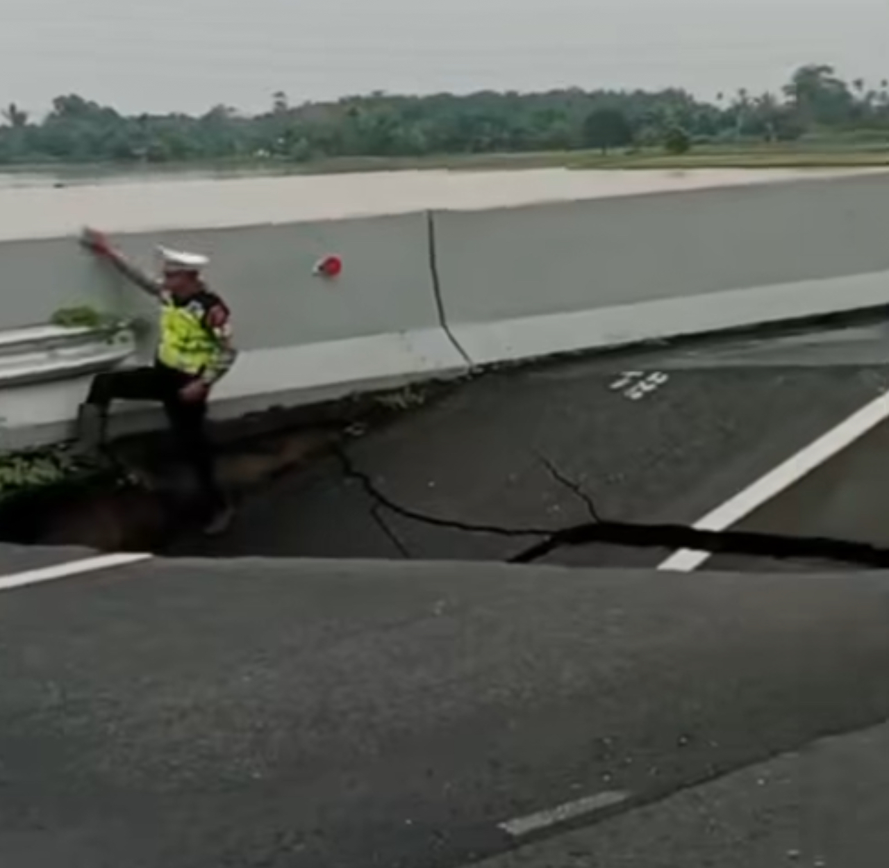 Petugas kepolisian tengah meninjau kondisi sesaat setelah jalan tol yang amblas di Km 41 ruas Tol Medan-Kualanamu-Tebingtinggi, Jumat (28/11/2025) siang.