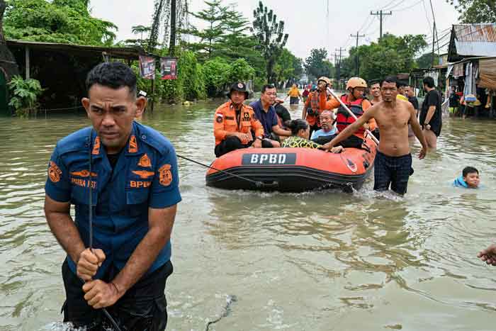 Tim penyelamat mengevakuasi seorang lansia menggunakan perahu karet saat banjir melanda Kota Medan, Provinsi Sumatera Utara, Jumat (28/11/2025).