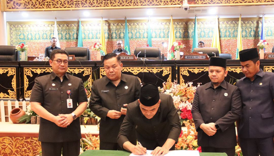 Ketua DPRD Riau Kaderismanto menandatangani notulen rapat paripurna disaksikan Plt Gubernur Riau SF Hariyanto dan Sekdaprov Riau Syahrial Abdi, Kamis (27/11/2025).