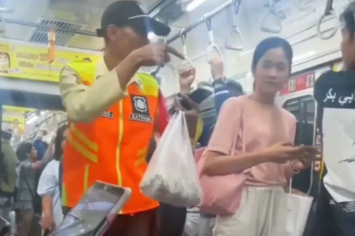 Satpam KRL yang terlihat panik saat menemukan bungkusan ansi uduk yang tertinggal di kereta.