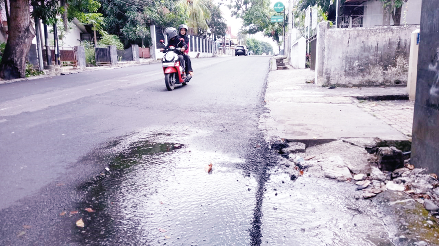Ruas Jalan Sultan Syarif Kasim, Kecamatan Limapuluh yang baru saja selesai di-overlay tergenang air dari kebocoran pipa PDAM Tirta Siak, Ahad (30/11/2025).