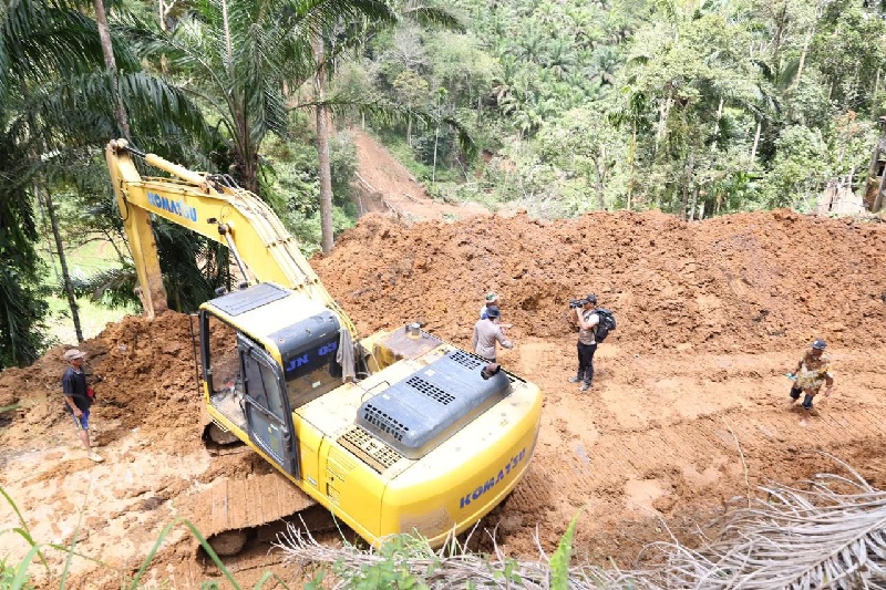 Alat berat yang dikirim Polda Riau saat bekerja membuka jalur yang terisolir di Kabupaten Agam, Sumatera Barat, Senin (1/12/2025).