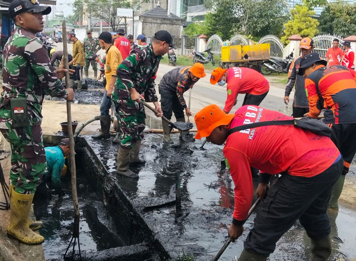 Personel gabungan melakukan pembersihan parit-parit di Jalan Lingkar, Tembilahan dalam upaya mitigasi menghadapi bencana hidrometeorologi, Senin (1/12/2025).