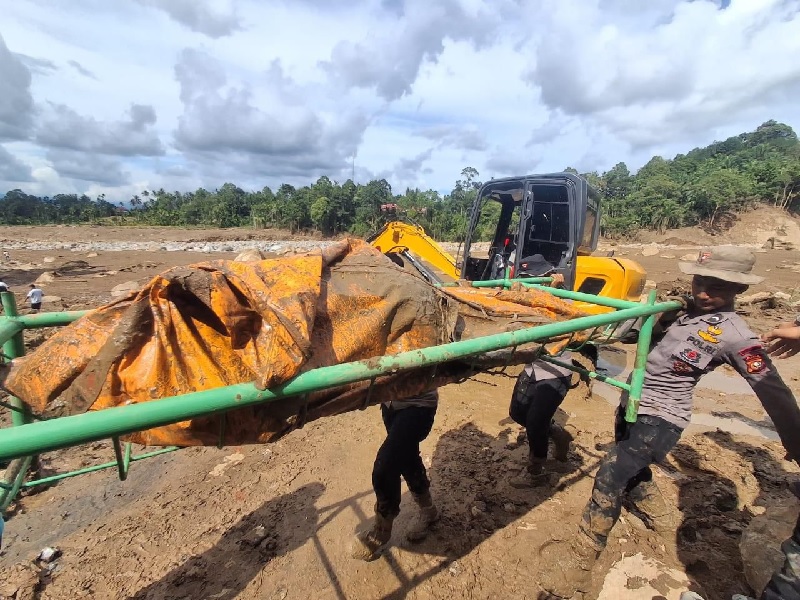 Personel BKO Polda Riau saat mengevakuasi jenazah ibu-anak korban banjir Agam, Senin (1/12/2025).