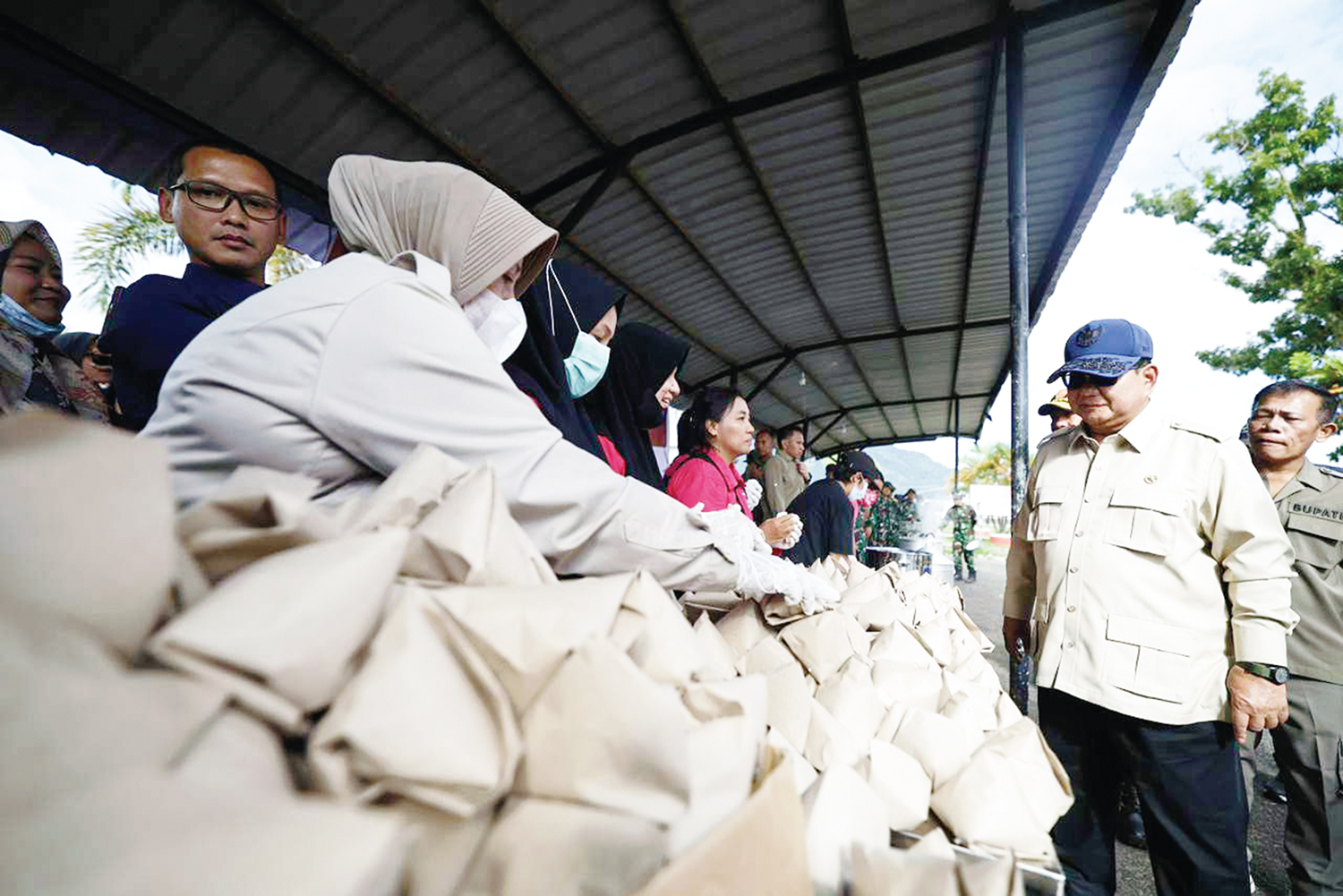 Presiden RI Prabowo Subianto melihat petugas menyiapkan makanan bagi para korban bencana  di posko pengungsian di Pandan, Tapanuli Tengah, Sumatera Utara, Senin (1/12/2025)