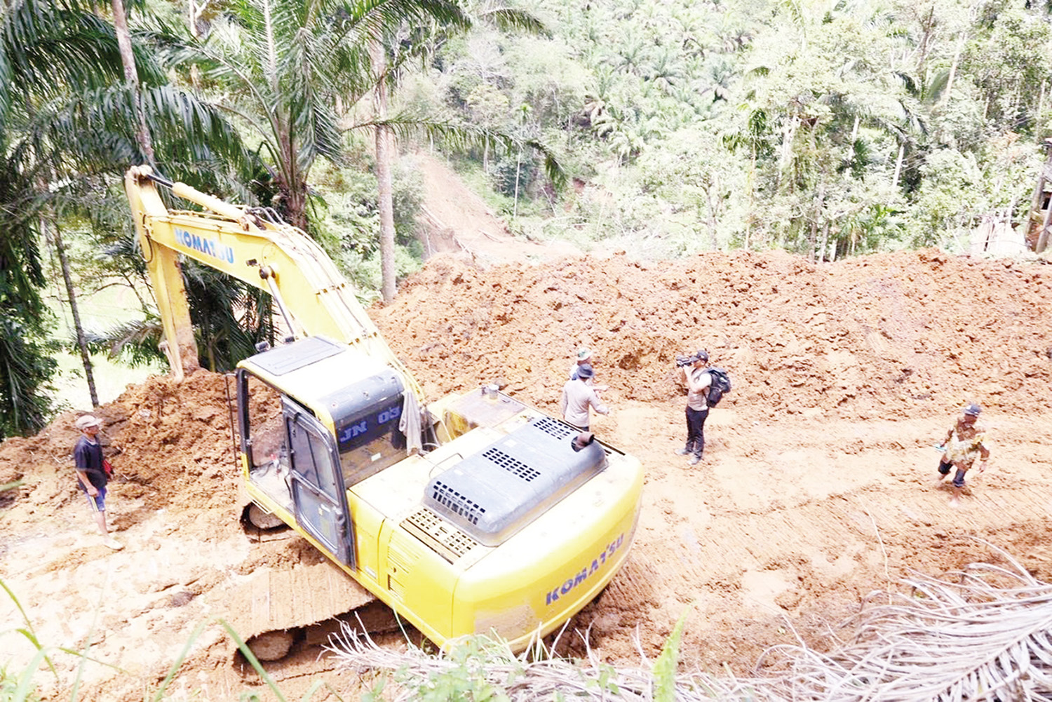 Alat berat kiriman Polda Riau bekerja membuka jalur yang terisolir di Agam, Sumatera Barat, Senin (1/12/2025).