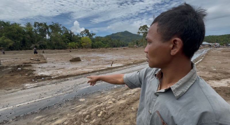 Warga Desa Selaras Air Kecamatan Palembayan Ilham menunjukan lokasi pemukiman yang sudah rata dengan tanah, Selasa (2/12/2025).