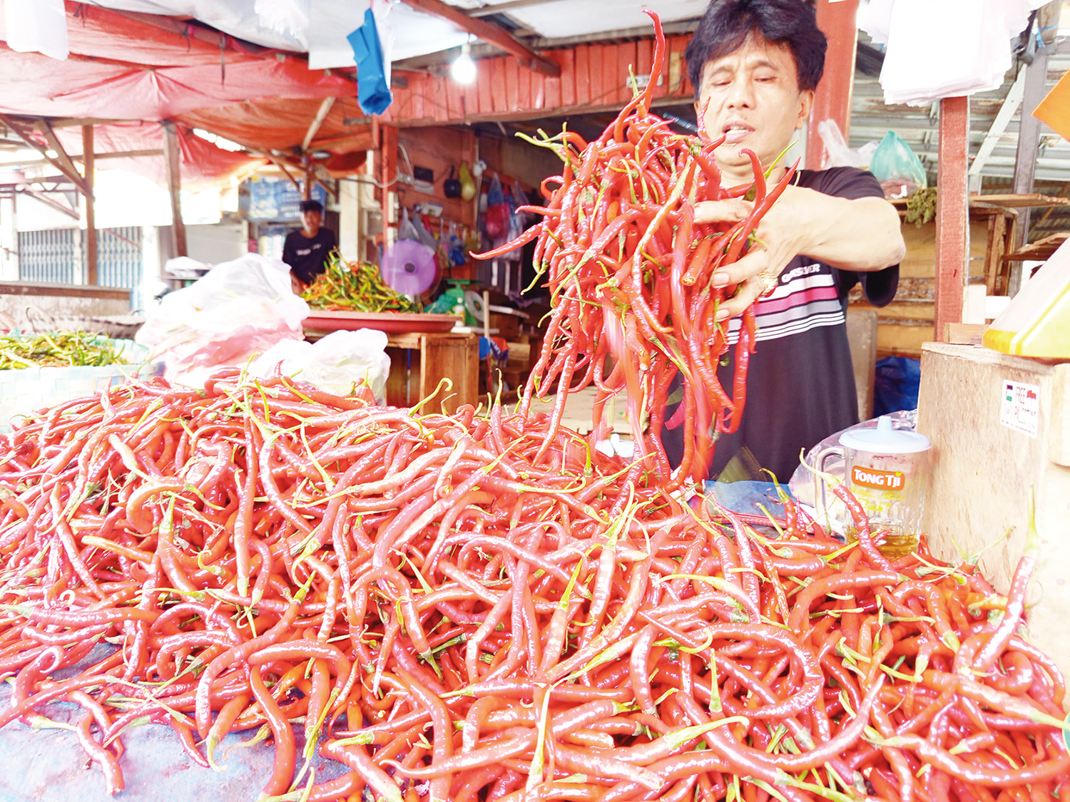 Pedagang memperlihatkan cabai merah di Pasar Agus Salim, Pekanbaru, Selasa (2/12/2025). Harga cabai naik drastis dampak bencana yang melanda Sumatera Barat.