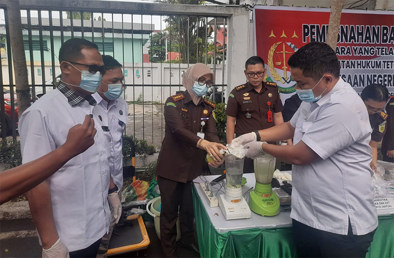 Kajari Pekanbaru Silpia Rosalina (bermasker) melakukan pemusnahan barang bukti perkara narkotika di halaman Kejari Pekanbaru, Rabu (3/12/2025).