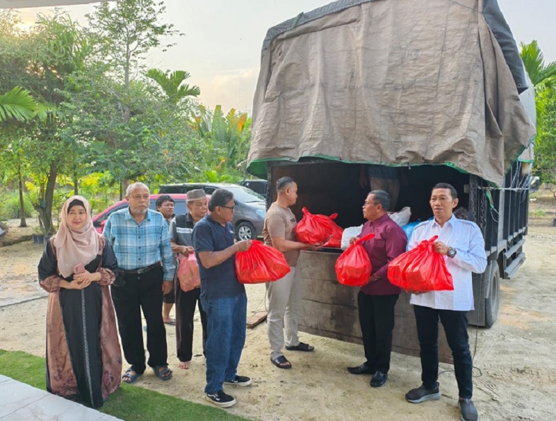 Ketua Umum IKSM Letkol Purn H Sutan Siregar (dua kanan) didampingi Ketua Harian AKP Kaliman Siregar (tiga kanan) memegang sembako bantuan untuk korban bencana di Sumut, Selasa (2/12/2025).