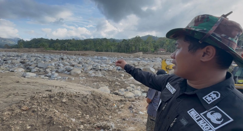 Wali Nagari Selaras Air Timur, Ahmad Fauzi, menunjukan lokasi rumah Fathan dan beberapa rumah warga lainnya yang habis tersapu banjir bandang pada Kamis (27/11/2025) lalu. Foto diambil Selasa (2/12).