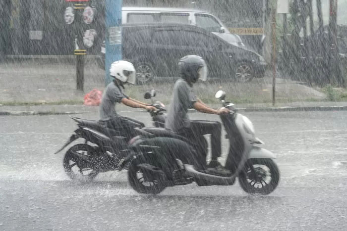 Ilustrasi pengendara menembus hujan yang mengguyur Kota Pekanbaru.