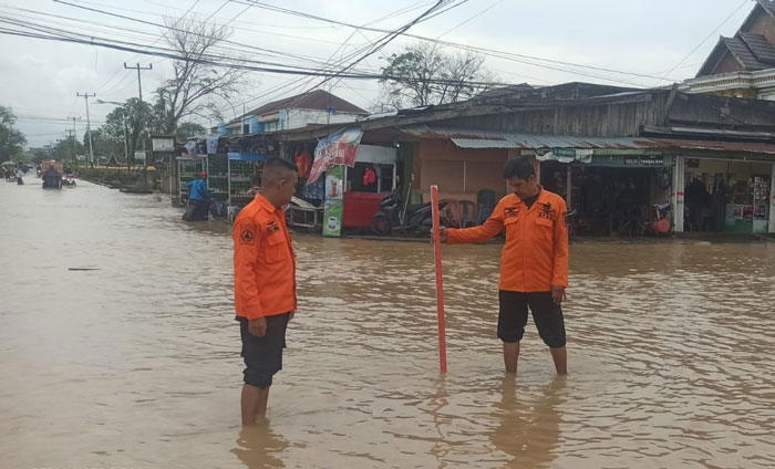 Petugas BPBD Inhil tengah memantau mobilitas air dan memberikan imbauan kepada warga untuk berhati-hati melintasi jalan yang digenangi air pasang rob di Tembilahan dan Tembilahan Hulu