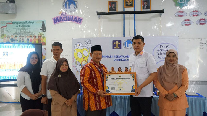 Kepala Kanwil Kemenkum Riau Rudy Hendra Pakpahan (dua dari kanan) menyerahkan cenderamata kepada Kepala SD Islam Al-Azhar 54 Pekanbaru Abdul Hakim di sela diseminasi di sekolah itu, Kamis (4/12/2025)