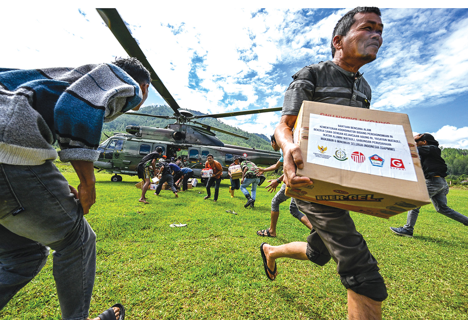BAWA BANTUAN: Warga korban banjir membawa satu kardus bantuan yang didistribusikan personel TNI AU di Kabupaten Bener Meriah, Provinsi Aceh, Kamis (4/12/2025).