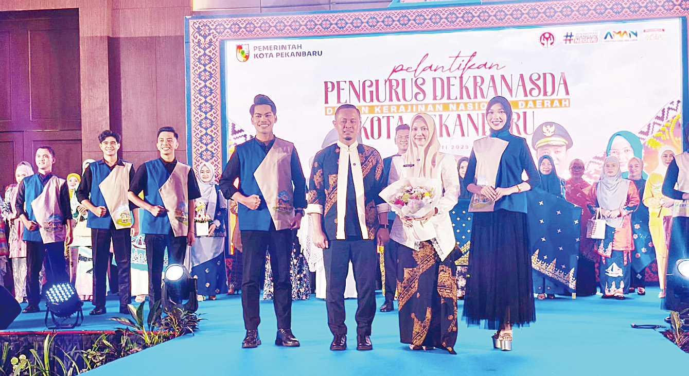 Ketua Dekranasda Pekanbaru Sulastri Agung didampingi Wako Pekanbaru Agung Nugroho menampilkan kreasi fashion dan songket dalam gelaran pelantikan pengurus Dekranasda Pekanbaru periode 2025-2030, Kamis (4/12/2025).