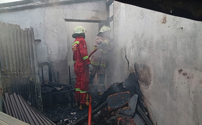 Petugas tengah melakukan upaya pemadaman dan pendinginan di lokasi kebakaran, Jalan Hunter, Kelurahan Perhentian Marpoyan, Kecamatan Marpoyan Damai, Jumat (5/12/2025).