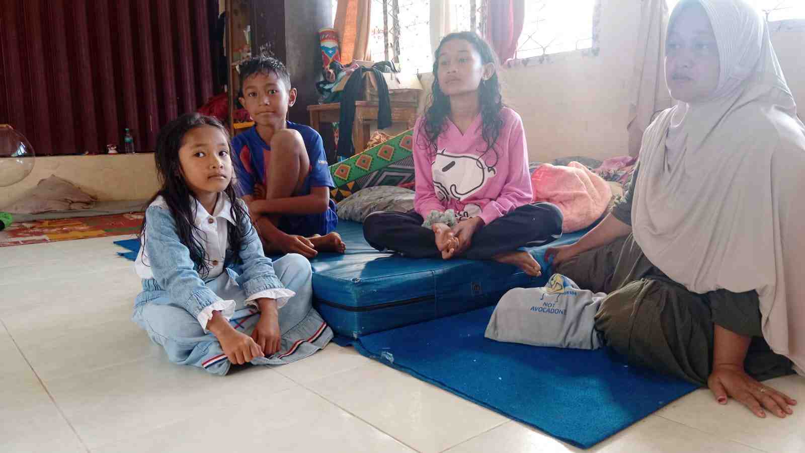 Yuni Efnita (kanan) bersama anak-anaknya tinggal di pengungsian di ruang kelas SDN 05 Kayupasak, Nagari Salarehaia, Kecamatan Palembayan, Kabupaten Agam, Sumbar, pascagalodo, Rabu (3/12/2025).
