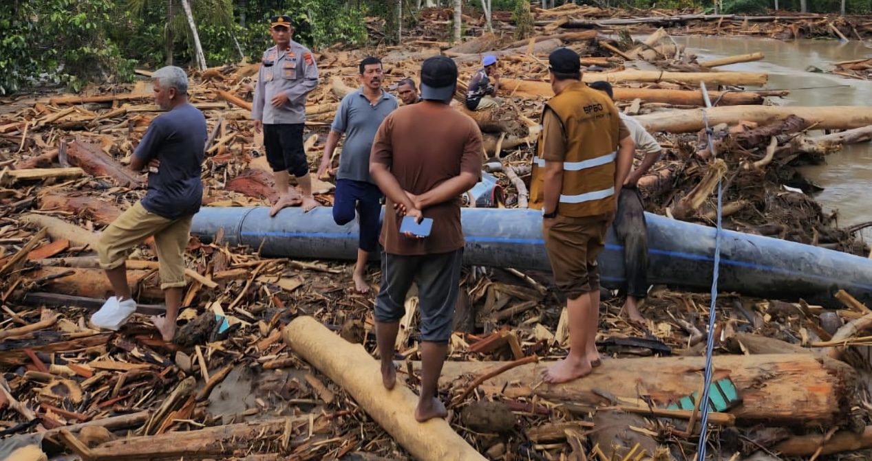 Tumpukan kayu yang dibawa arus banjir bandang memenuhi badan DAS Krueng Meureudu, Pidie Jaya, Aceh, menyebabkan air membuka aliran baru ke perkampungan warga.