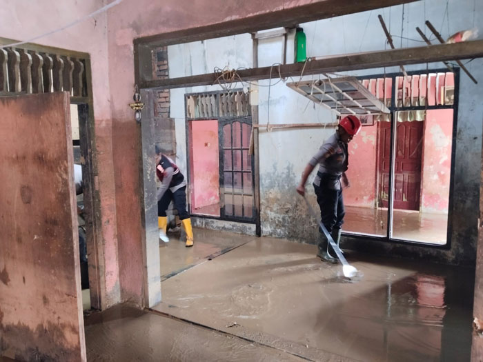 Personel Sar Samapta Polda Riau saat melakukan pembersihan salah satu rumah warga yang berlumpur di Kecamatan Palembayan, Kabupaten Agam, Ahad (7/12/2025).