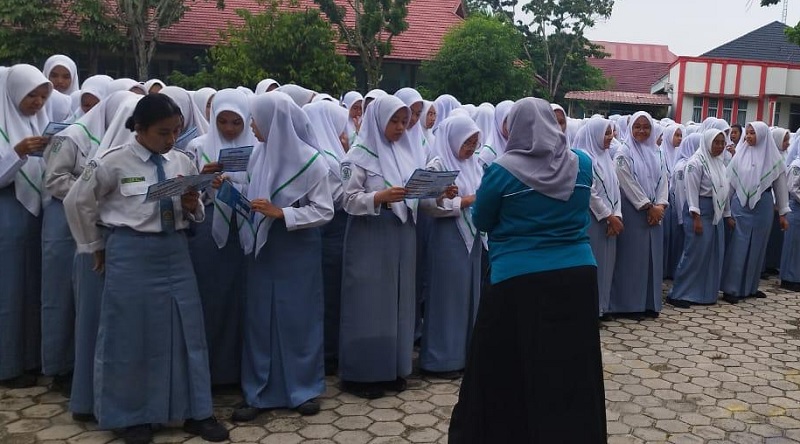Dosen Teknologi Laboratorium Medis Universitas Abdurrab Fatma, S. Tr. Kes., M. Kes memandu siswa Siswa SMKF Ikasari saat pengisian kuesioner faktor risiko penyakit tidak menular Senin (8/12/2025).