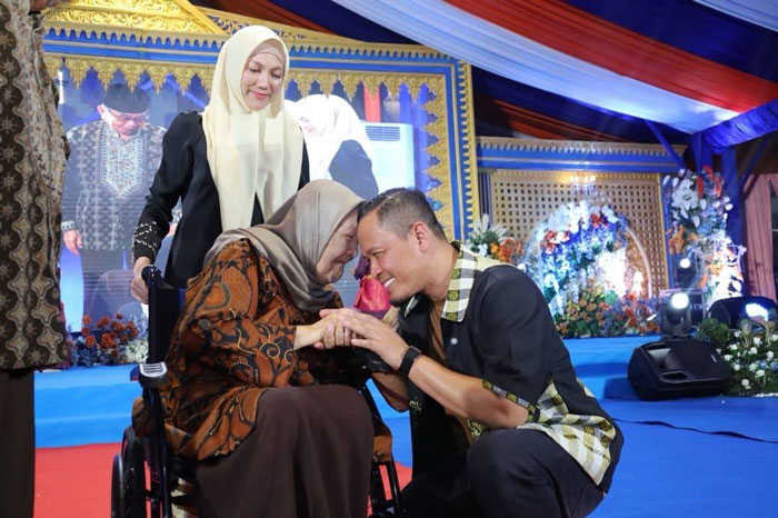 Wako Pekanbaru Agung Nugroho didampingi Ketua TP PKK Pekanbaru Sulastri Agung bersalaman dan memberikan penghormatan pada guru saat Malam Apresiasi dan Gala Dinner Puncak HGN 2025, Ahad (7/12/2025).