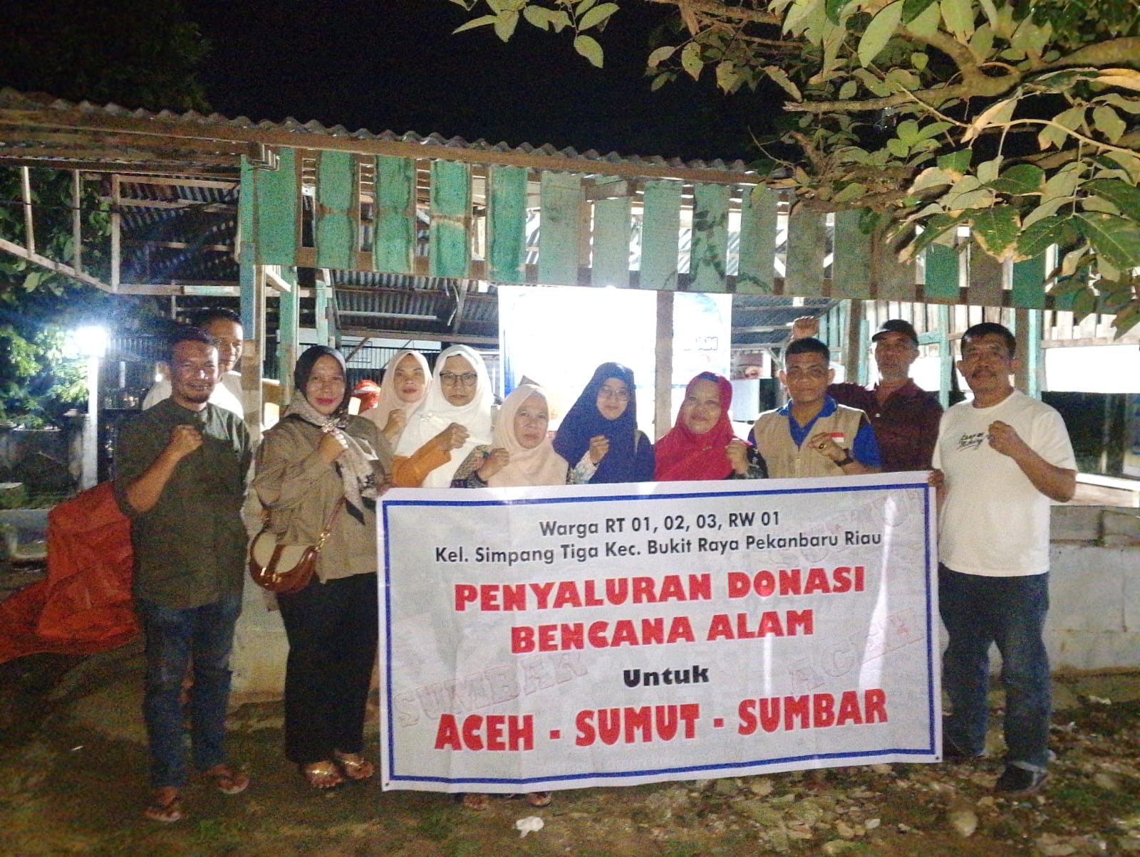Relawan bantuan korban bencana Simpangtiga dan Lurah Simpangtiga Harmendra SSos  foto bersama usai penyerahan bantuan bencana Sumatera, Sabtu (6/12/2025).