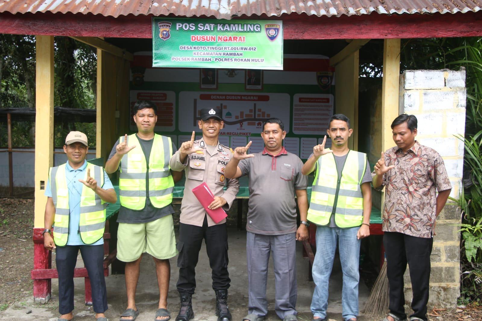 Bhabinkamtibmas Desa Koto Tinggi Bripka Nasrul Jamil (3 kiri) foto bersama warga di depan Pos Satkamling Dusun Ngarai Desa Koto Tinggi RT 001/RW 012 Kecamatan Rambah.